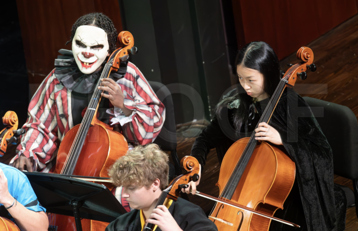 Students are dressed up while attentively reading and playing the assigned music. 